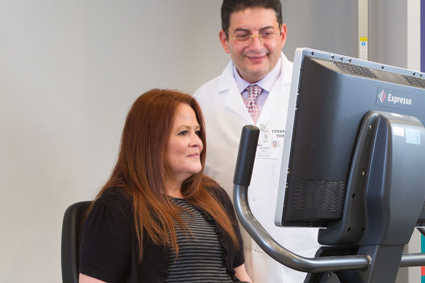 Cardiopulmonary patient getting help on exercise cycle